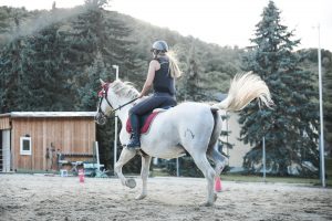 Vrouw zit op een wit paard