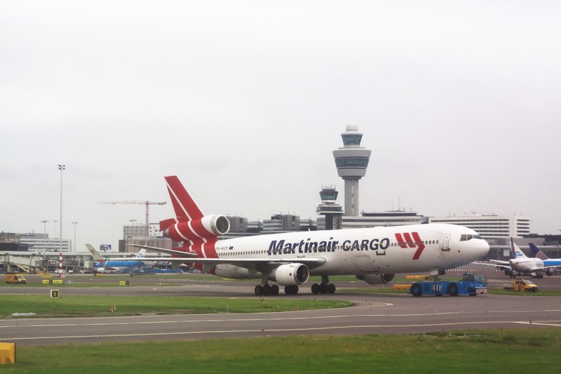 Schiphol met verkeerstoren op de achtergrond en vrachtvliegtuig van Martinair op de voorgrond
